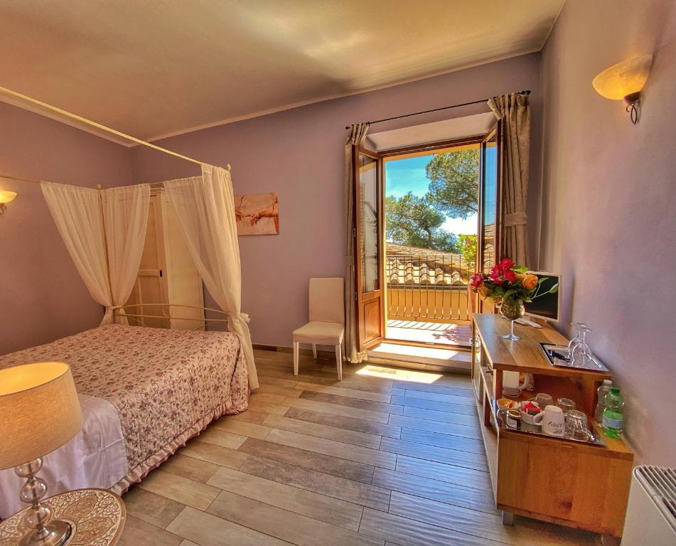 1 dormitorio con 1 cama y puerta a un balcón en Piazzetta Del Buonumore en Montepulciano