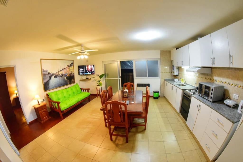 uma cozinha e sala de estar com uma mesa e um sofá verde em Departamento Centro con cochera gratis em Paraná