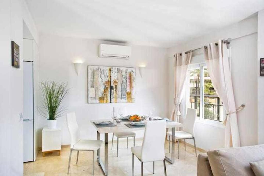 マルベーリャにあるBEST LOCATION apartment in MARBELLA. BEACHFRONT!!の白いダイニングルーム(テーブル、椅子付)