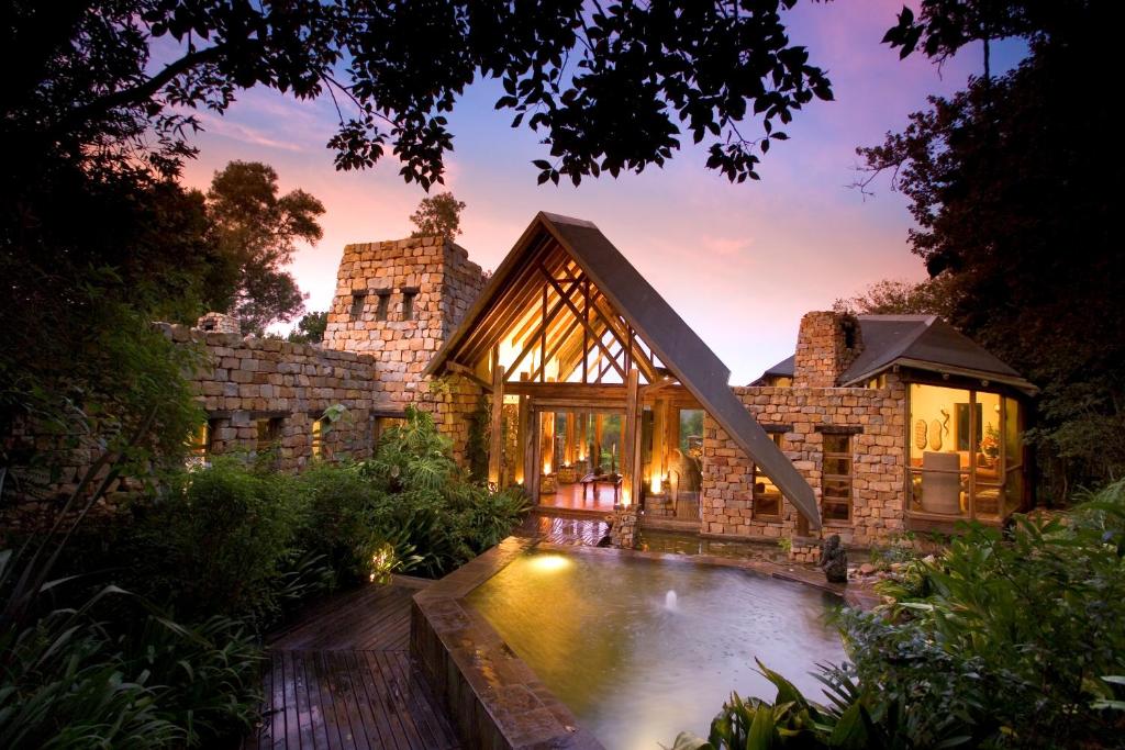 une maison avec une piscine dans la cour dans l'établissement Tsala Treetop Lodge, à Plettenberg Bay