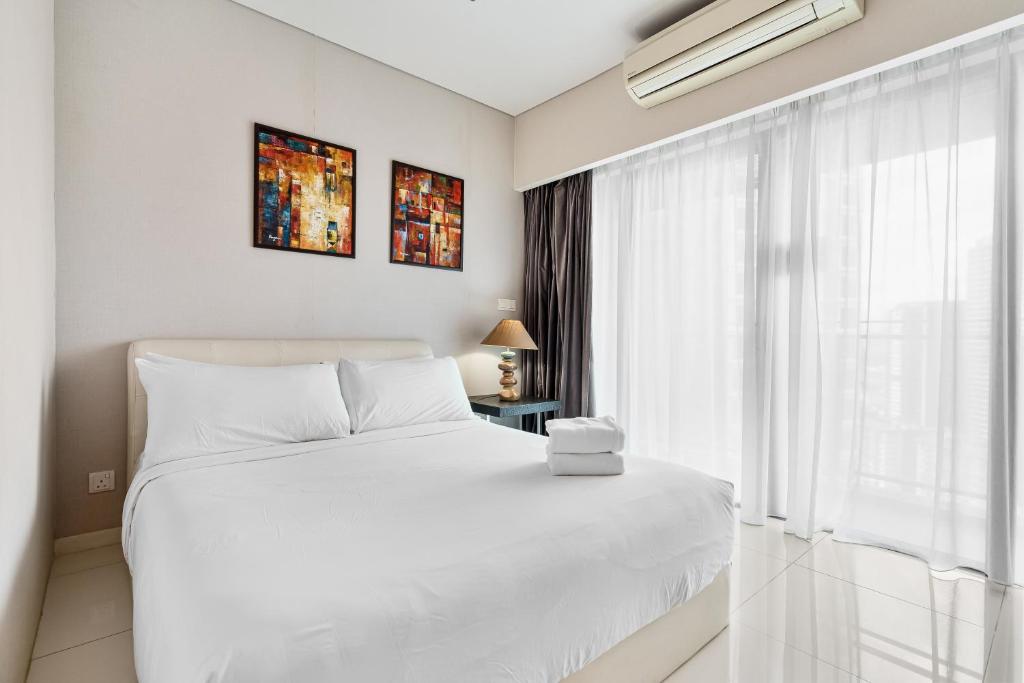 a white bedroom with a white bed and a window at Summer Suites KLCC Apartments in Kuala Lumpur