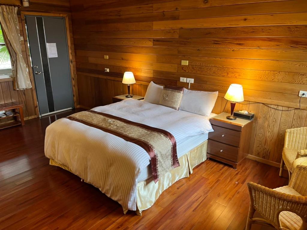 a bedroom with a large bed with wooden walls at Ye Jiang Hua Homestay in Meishan