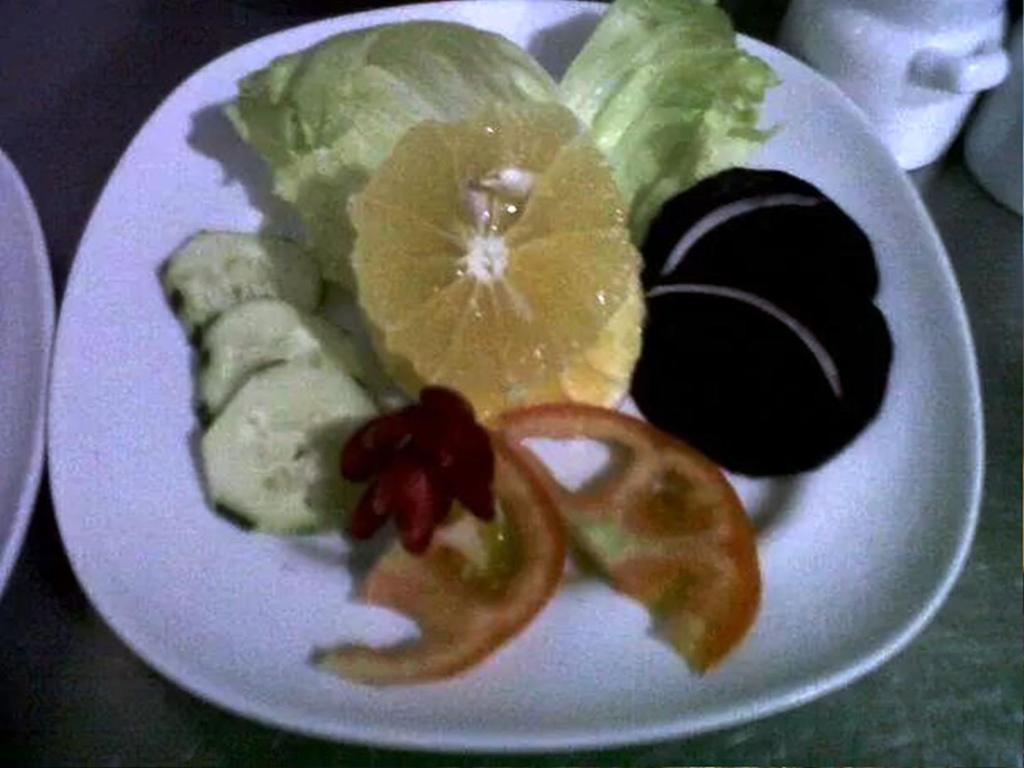 a white plate of food with fruit and vegetables at Pacific Bay Resort in Boca Chica