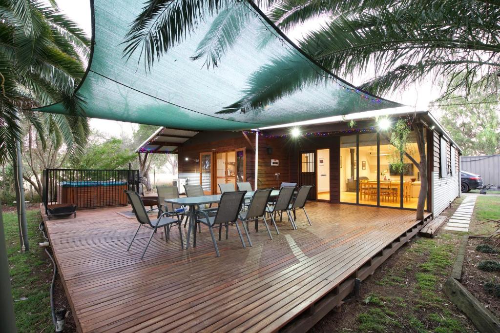 a wooden deck with a table and chairs on it at Goolwa River Retreat in Torrumbarry