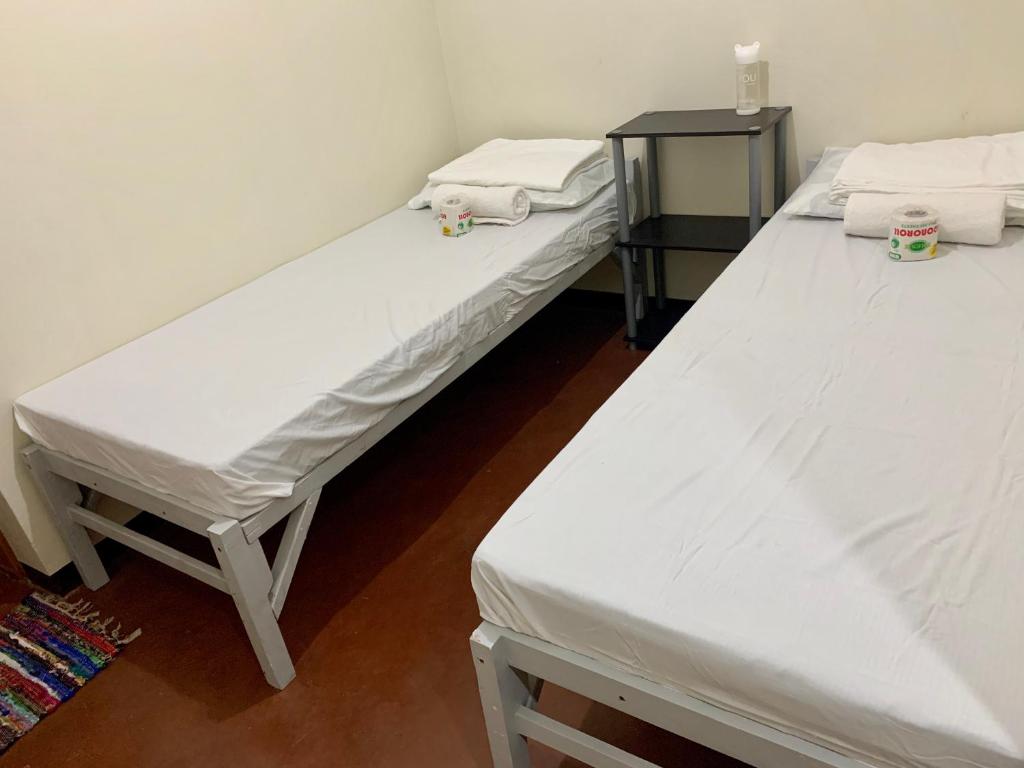 - 2 lits dans une chambre avec des draps blancs dans l'établissement Mybed Dormitory, à Cebu