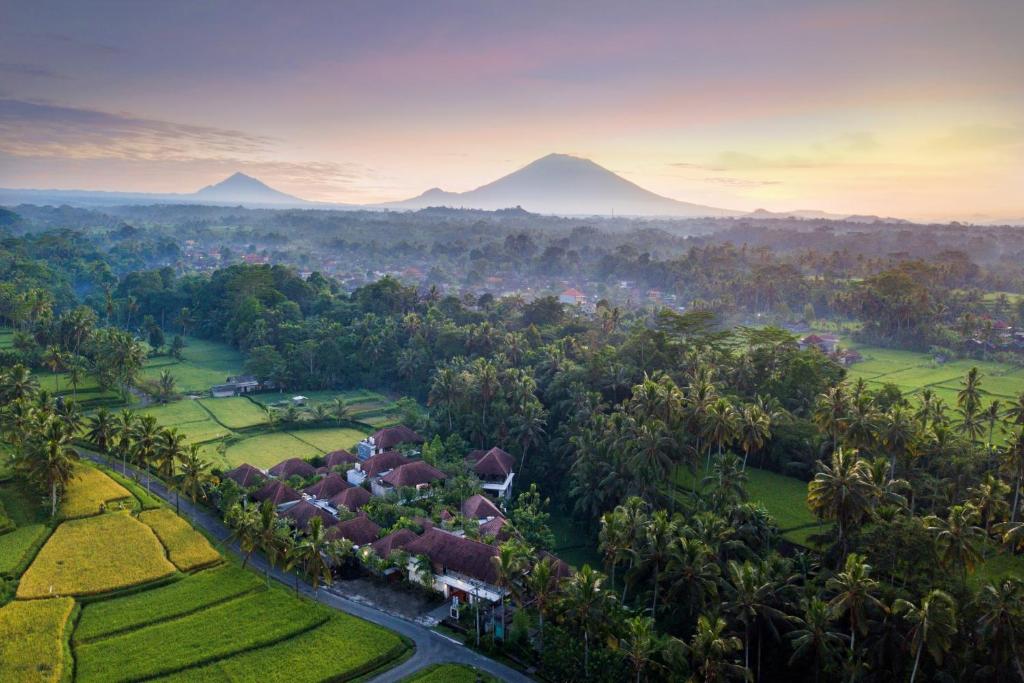 uma vista aérea de uma aldeia com montanhas ao fundo em Dedary Resort Ubud by Ini Vie Hospitality em Ubud
