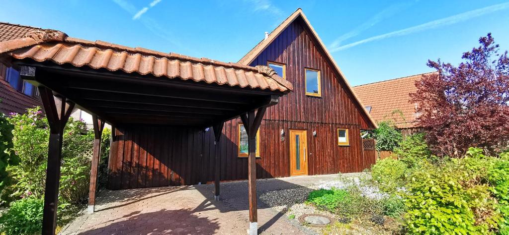a large wooden house with a brown roof at Ferienhaus Heidegeist "nähe Heidepark & Outlet Center" in Soltau