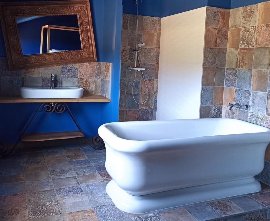 a bathroom with a white bath tub and a sink at Sous Les Pins gîtes et chambres d'hôtes in La Londe-les-Maures