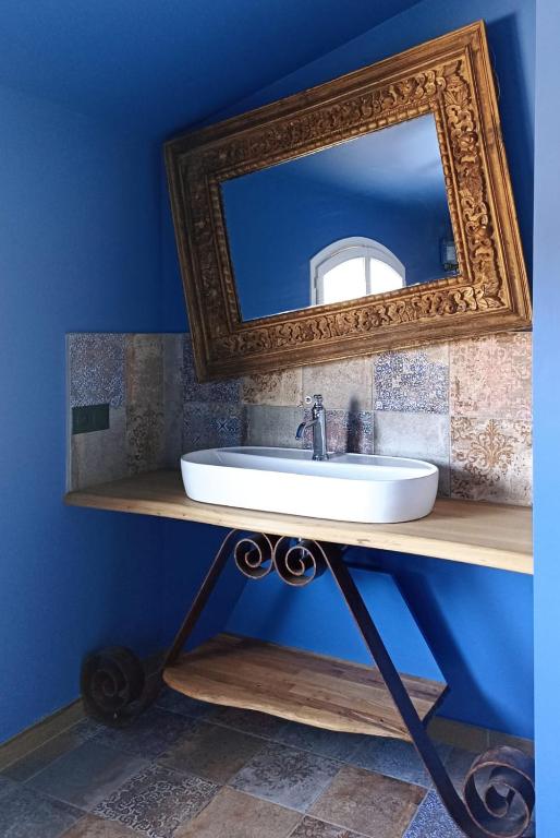 a bathroom with a sink and a mirror on a blue wall at Sous Les Pins gîtes et chambres d'hôtes in La Londe-les-Maures