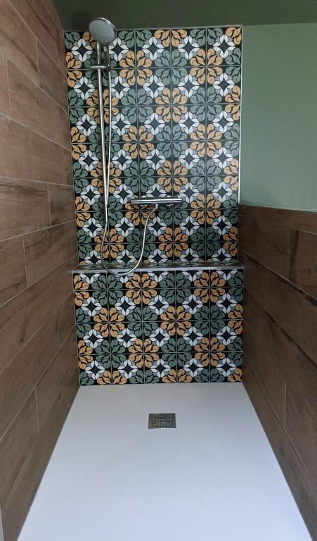 a bathroom with a tiled wall with a shower at Sous Les Pins gîtes et chambres d'hôtes in La Londe-les-Maures