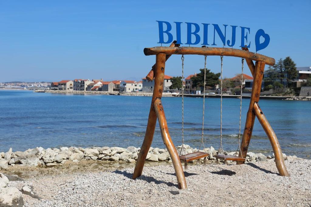 a wooden swing on the beach near the water at antonio in Bibinje