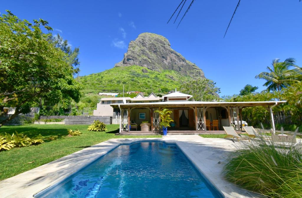 a house with a pool in front of a mountain at Villa Alira in Le Morne