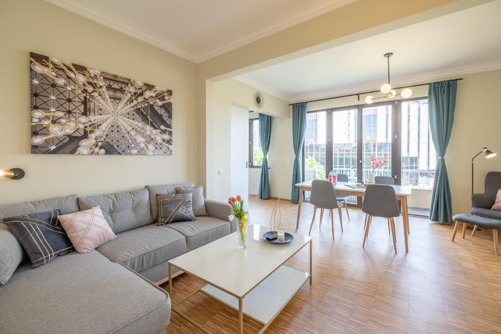 ein Wohnzimmer mit Sofa und Tisch in der Unterkunft Sunrise 1BDRM View Apartment NDK Congress Centre in Sofia