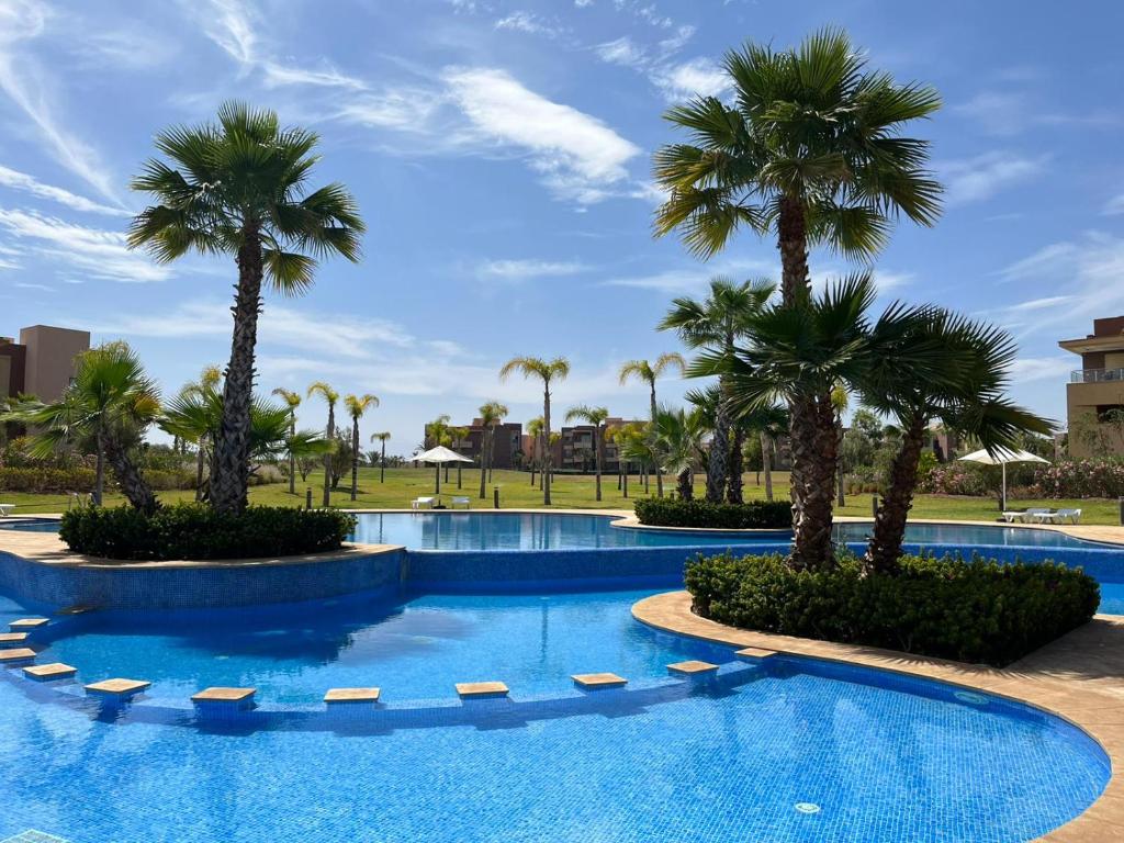 basen z palmami w ośrodku w obiekcie Appartement de Luxe -Prestigia Marrakech Golf City w Marakeszu