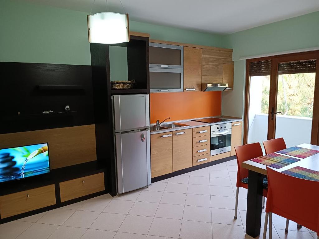 una cucina con frigorifero e tavolo con TV di Family Beach 100 Square Metres Apartment a Golem