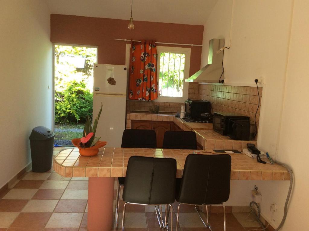 a kitchen with a counter and some chairs in a room at LA KAZ A DADA in Sainte-Suzanne