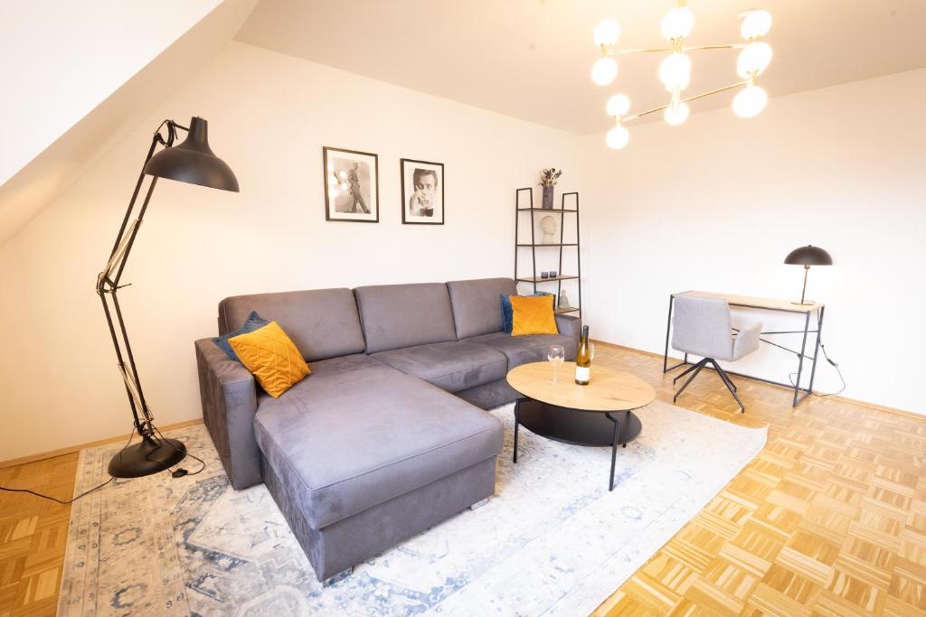 uma sala de estar com um sofá e uma mesa em Lahn-Living III - modernes und helles Apartment mit Top Ausstattung em Lahnstein
