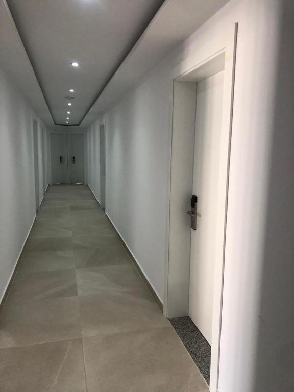 an empty hallway with white walls and a door at Hotel MARIO, Shengjin in Shëngjin