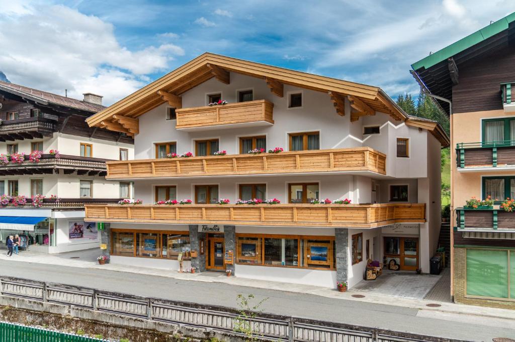 ein Gebäude mit Holzbalkonen neben einem Bahnhof in der Unterkunft Central Filzmoos in Filzmoos