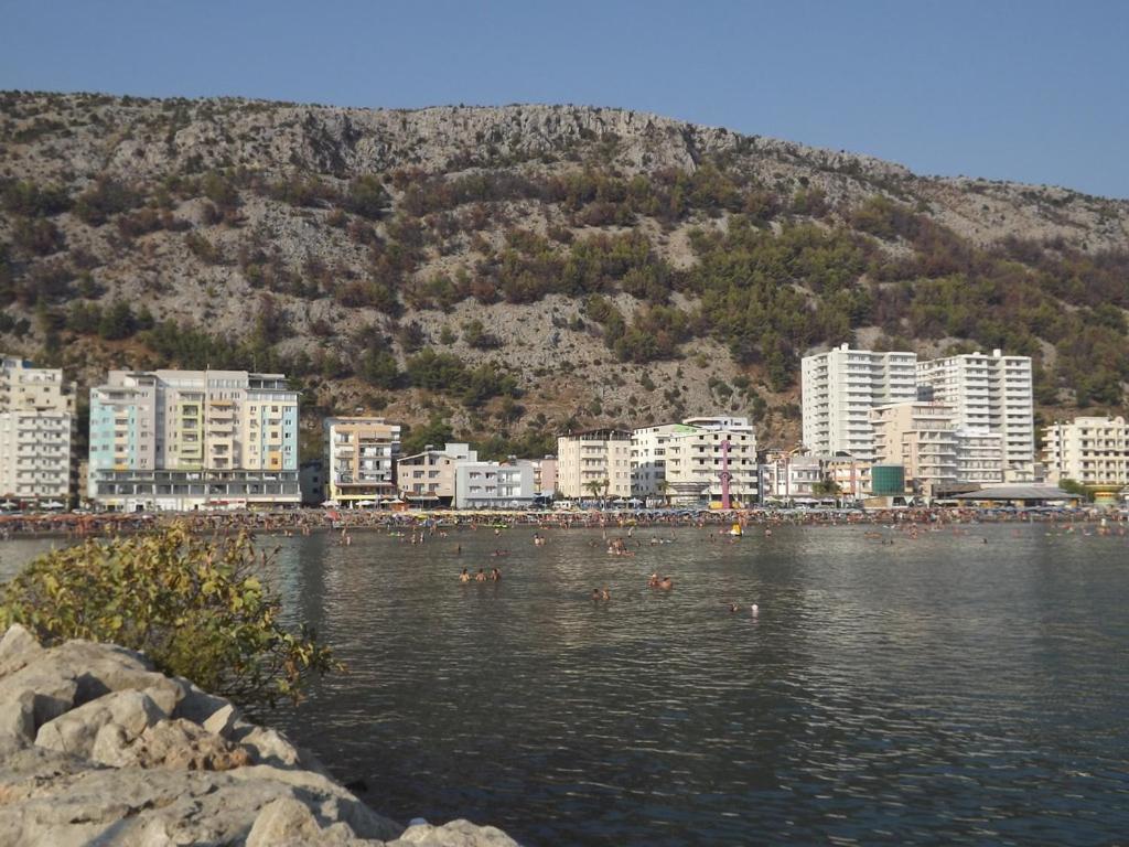 a group of people swimming in a lake in a city at Hotel MARIO, Shengjin in Shëngjin