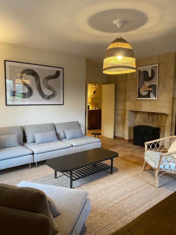 a living room with a couch and a fireplace at Appartement de caractère à la Roque-Gageac in La Roque-Gageac