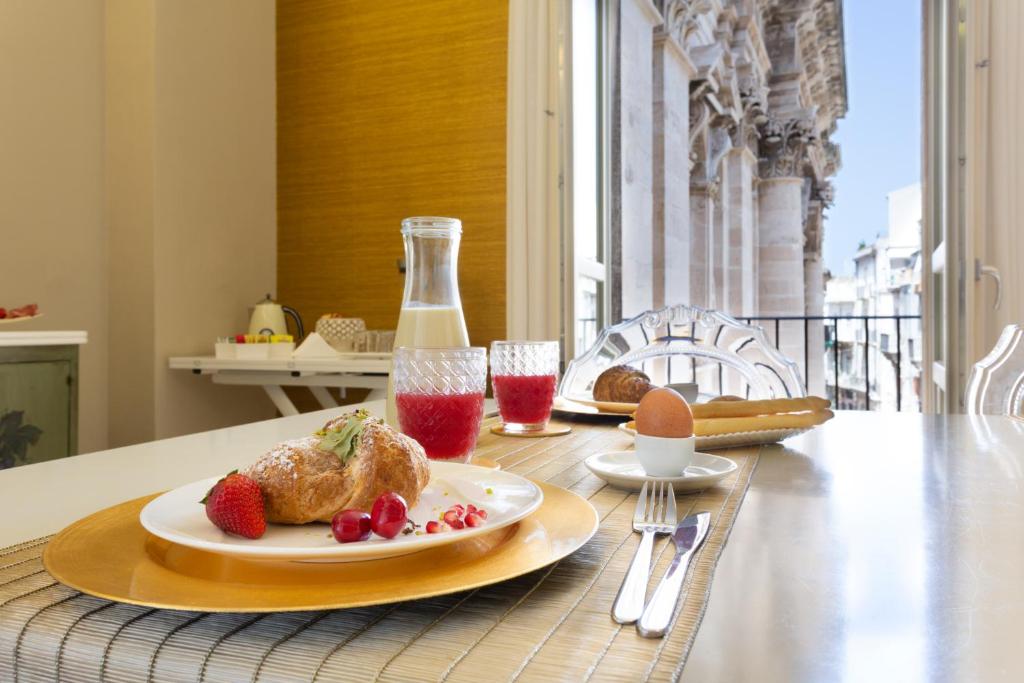 een tafel met een bord eten en een fles melk bij Maecò Ortigia B&B in Siracusa