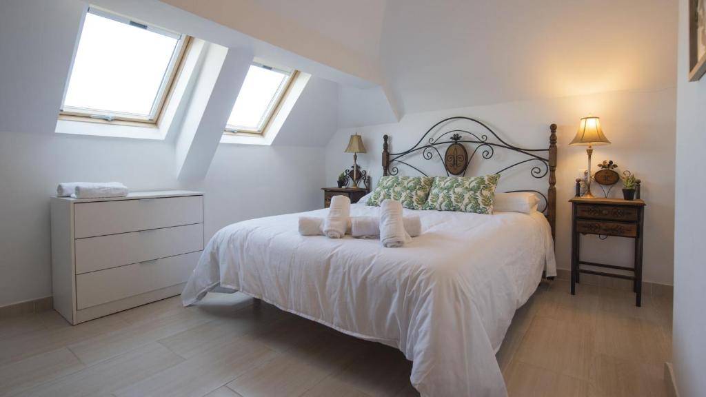een slaapkamer met een groot wit bed met 2 kussens bij Pico Limón in Toledo