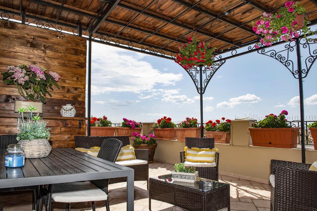 a patio with a table and chairs and flowers at Case I Gerani in Alghero