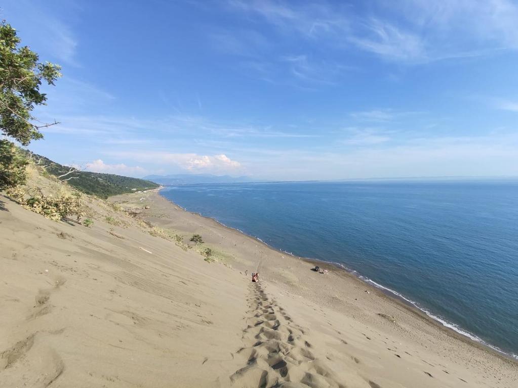 a beach with footprints in the sand next to the ocean at Hotel MARIO, Shengjin in Shëngjin