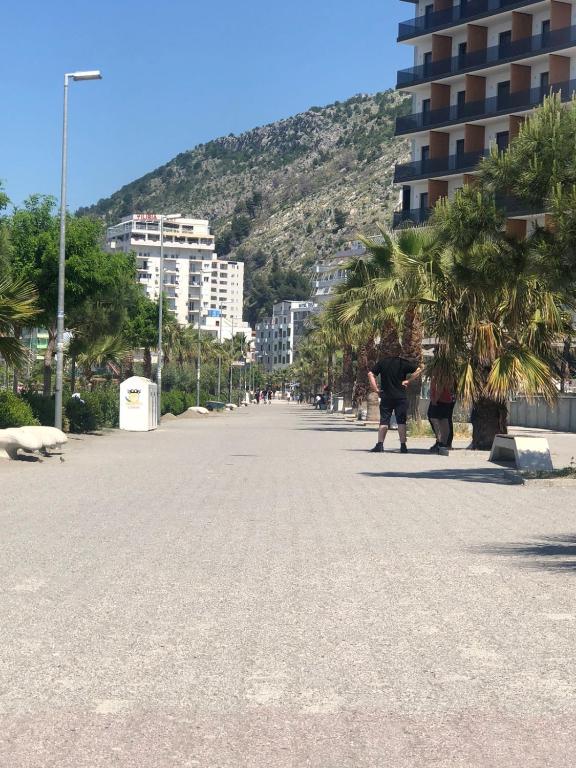 a city street with palm trees and a mountain at Hotel MARIO, Shengjin in Shëngjin