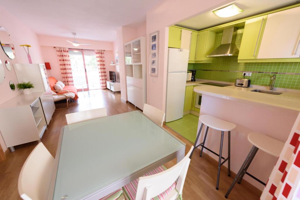 uma cozinha com armários verdes e brancos e uma mesa em Apartamentos Nuevo México C 431 em Calpe