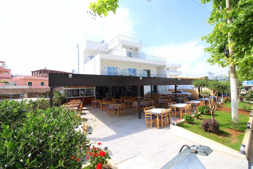 a patio with tables and chairs in front of a building at Moonshine Hotel in Ksamil