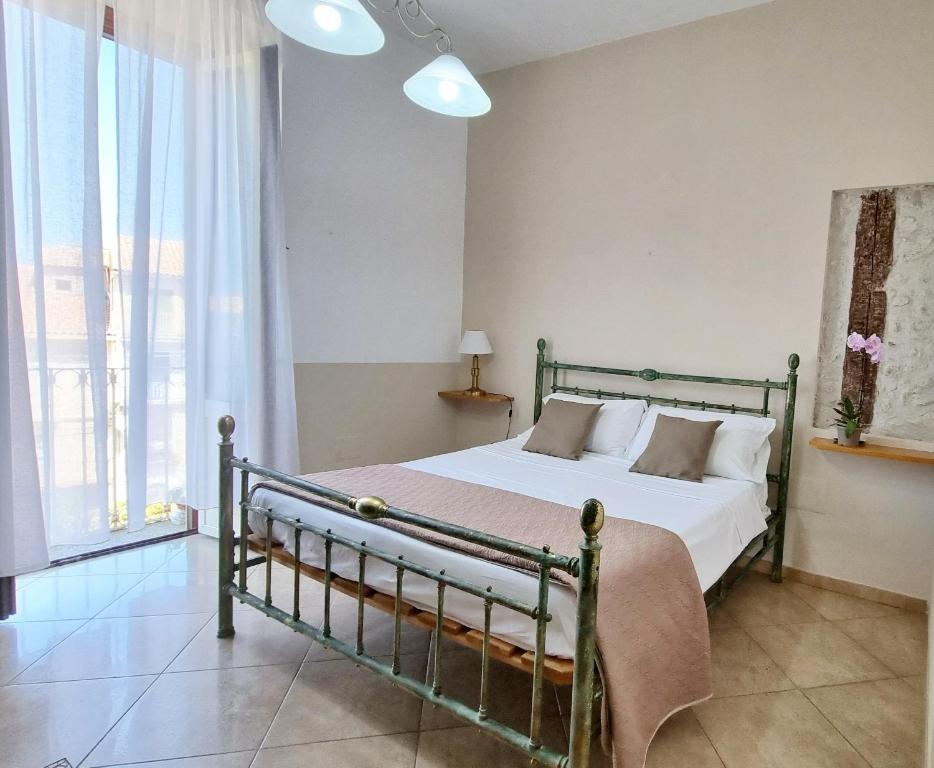 a bedroom with a bed and a large window at Artemisia in Tropea