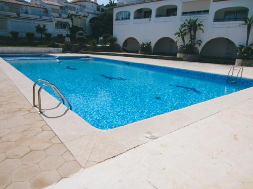 - une piscine d'eau bleue en face d'un bâtiment dans l'établissement Casa Clare - 3 bedroom apartment in Denia, à Dénia