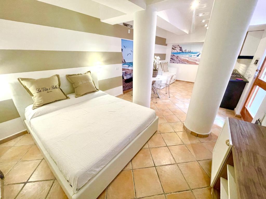 a bed in a room with a column at Maison Del Conero - Ombrellone e Lettini in Spiaggia Inclusi in Numana