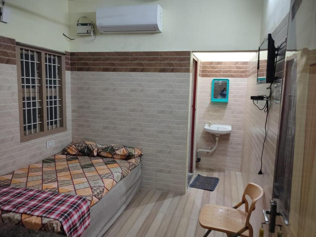 1 dormitorio con 1 cama y baño con lavamanos en SRI VARI RESIDENCY en Vellore