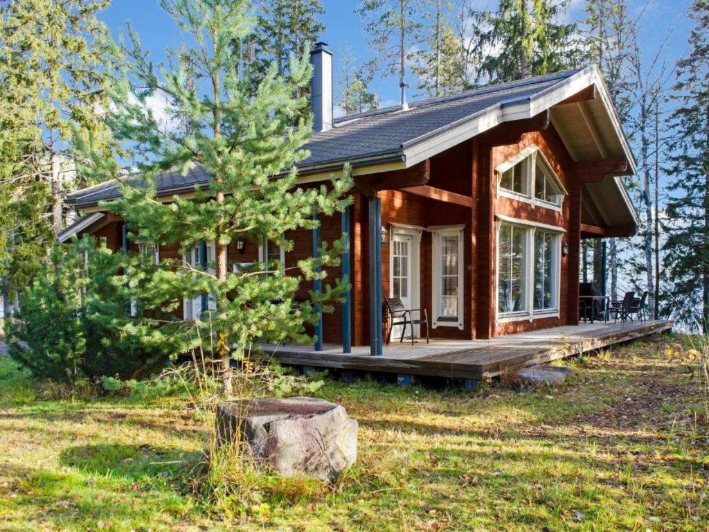 a small log cabin in the woods with a porch at Holiday Home Amero purnu 2 in Kolinkylä