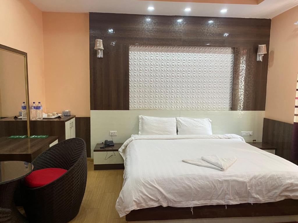 a bedroom with a bed and a chair and a window at Hotel Gorkha Palace Pvt. Ltd in Gorkhā