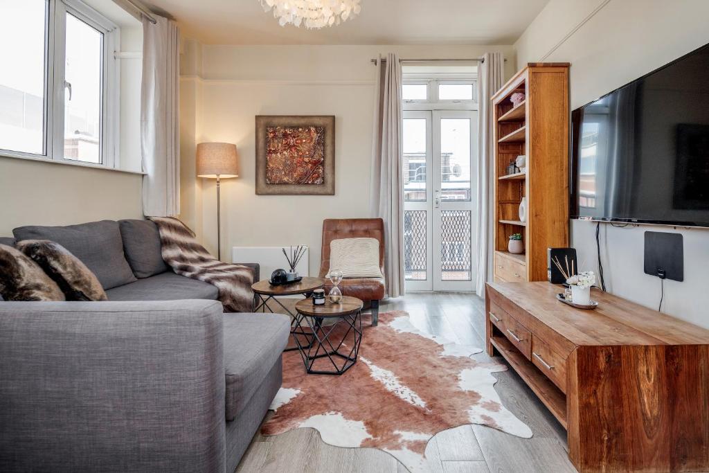 a living room with a couch and a flat screen tv at Perfect Location 2 Bed South Kensington Knightsbridge Chelsea with AC in London