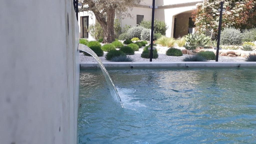 uma fonte de água numa piscina num quintal em Le Clos d'Antonelle em Aix-en-Provence