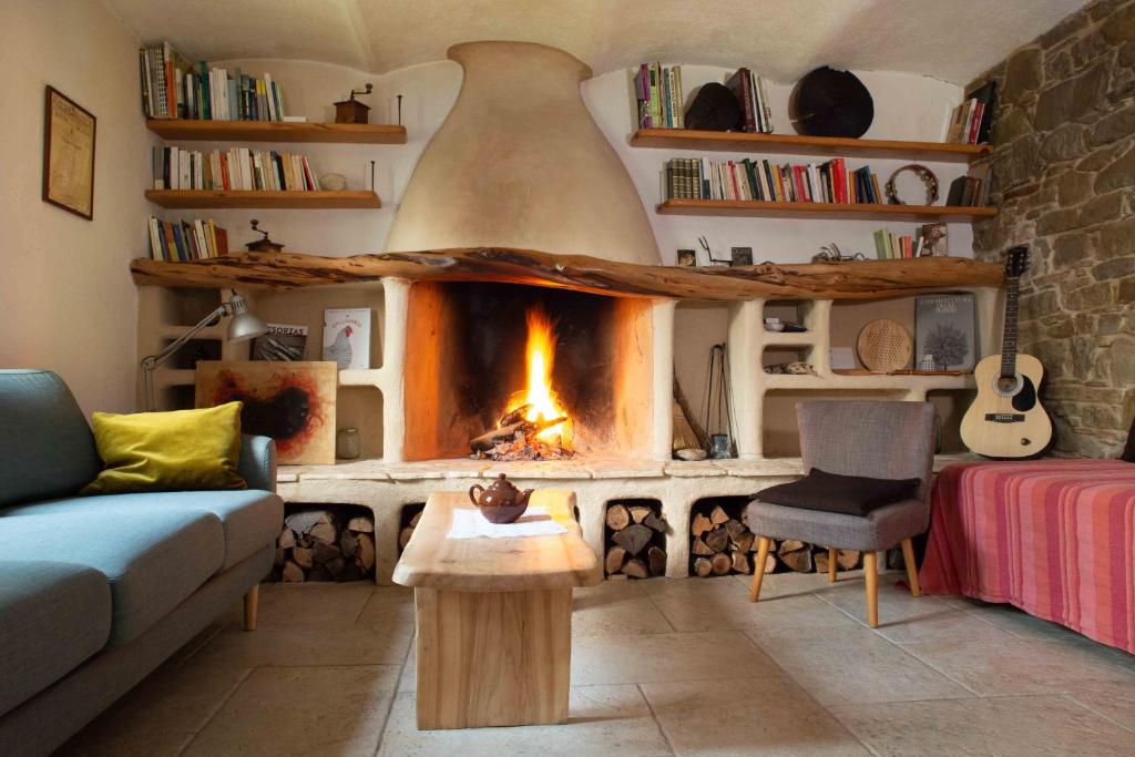 sala de estar con chimenea y sofá en Cà Colmello - Country House, en Gesso