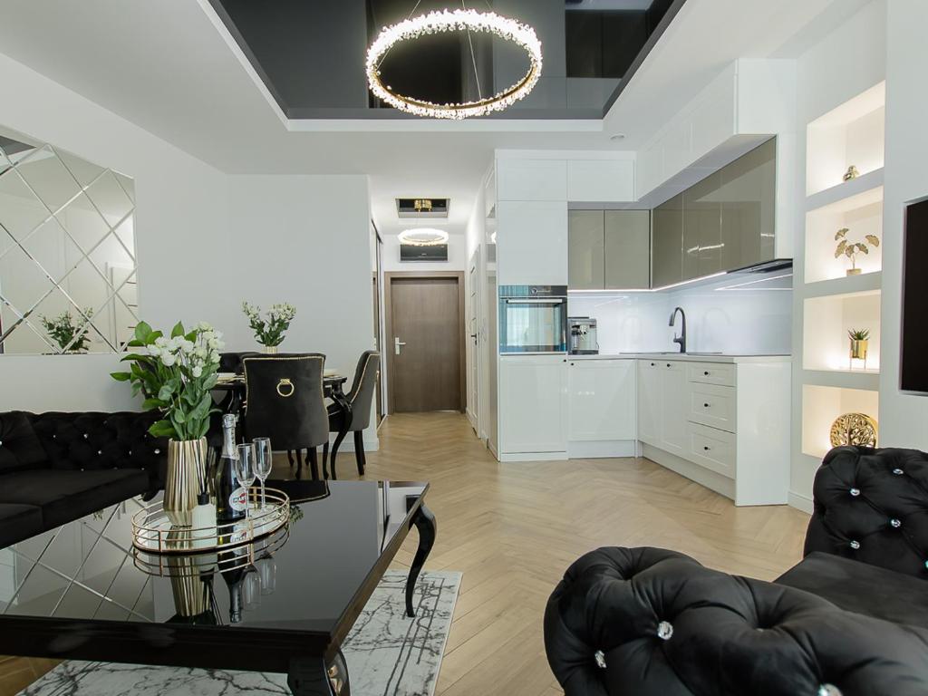 a living room with a table and a kitchen at Aquarius Residence apartament 203 in Boszkowo