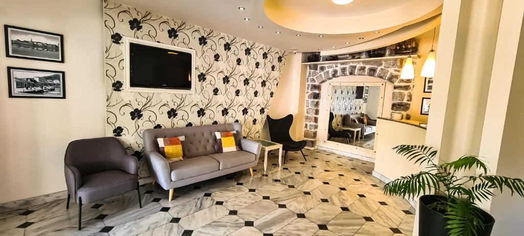 a waiting room with a couch and a tv at Hotel Villa Perla Di Mare in Budva