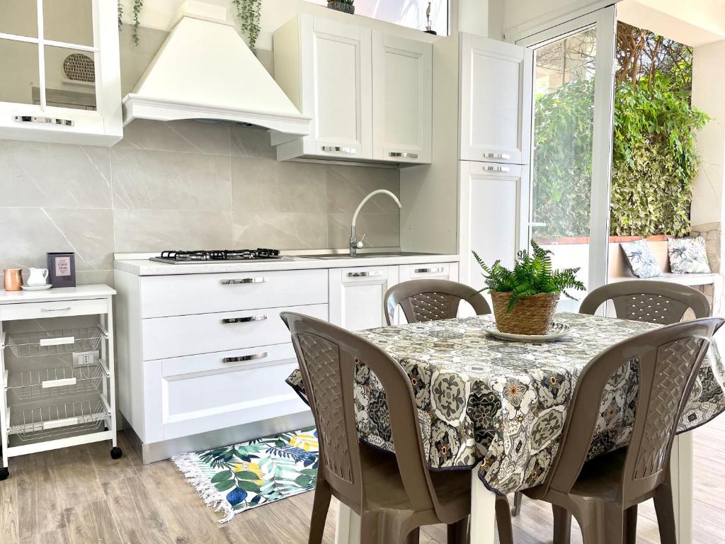 a kitchen with a table with chairs and a sink at Casa Safari in Marzamemi