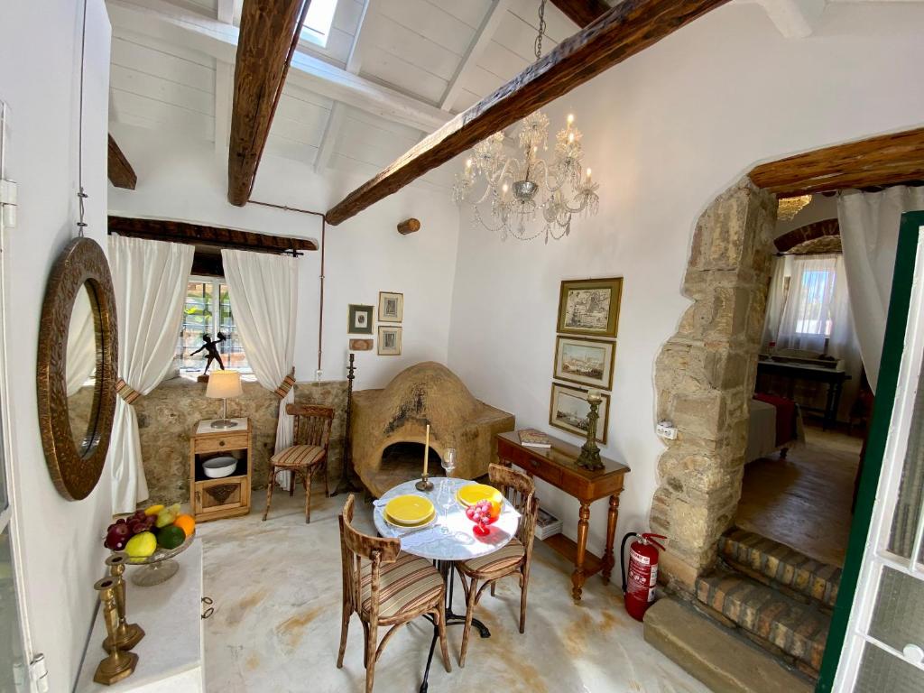 a living room with a table and a stone fireplace at Corfu Rural-Chic Gems in Ágios Prokópios