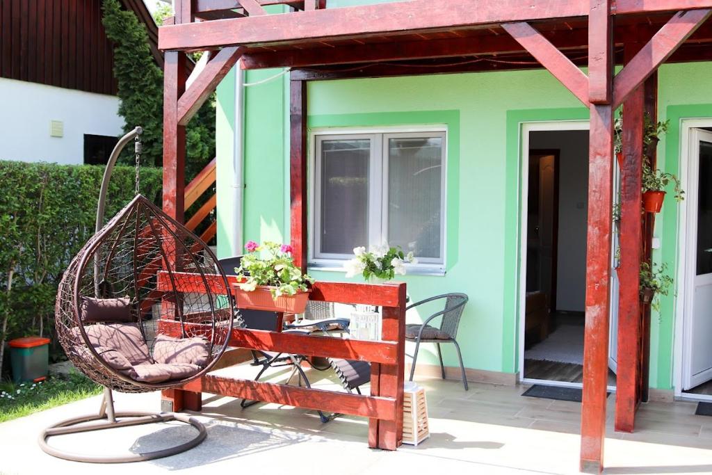 a patio with a swing and a house at Charming studio Maša in Palić