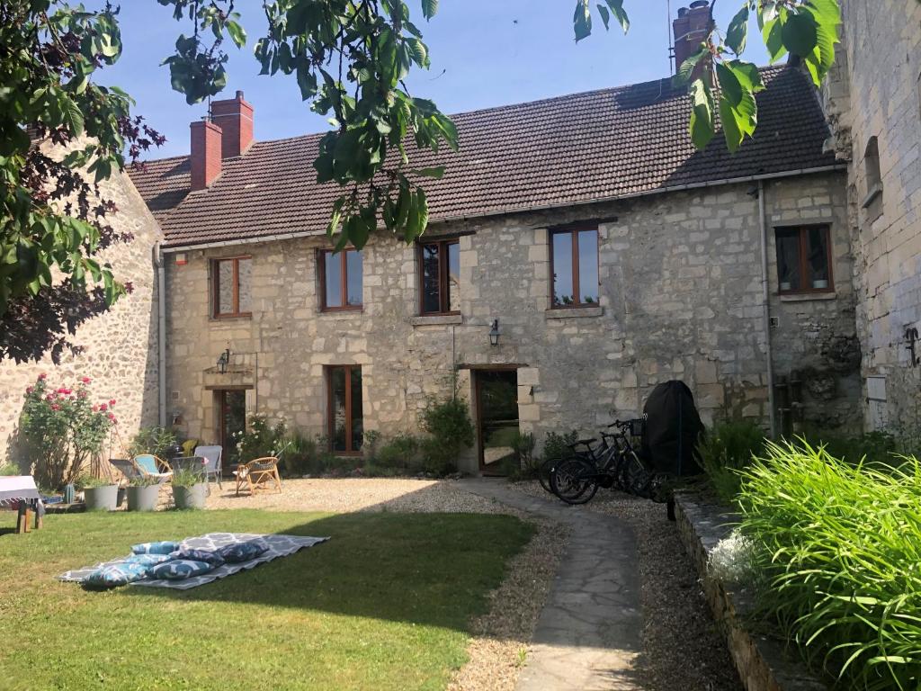 una vieja casa de piedra con bicicletas estacionadas en el patio en Maison de famille du 17ème siècle, 