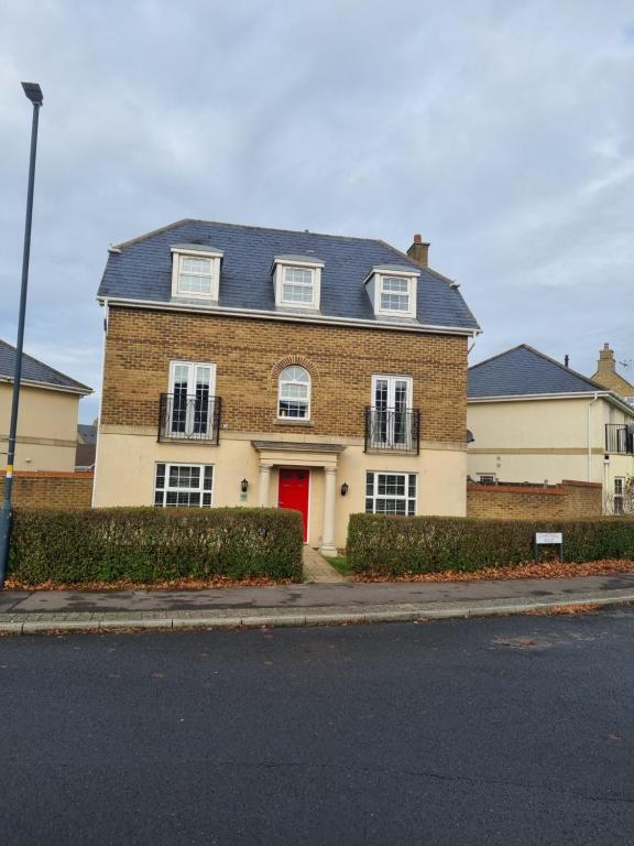 a brick house with a red door on a street at Swindon 6 deluxe doubles 2 with en suite in large house in Swindon