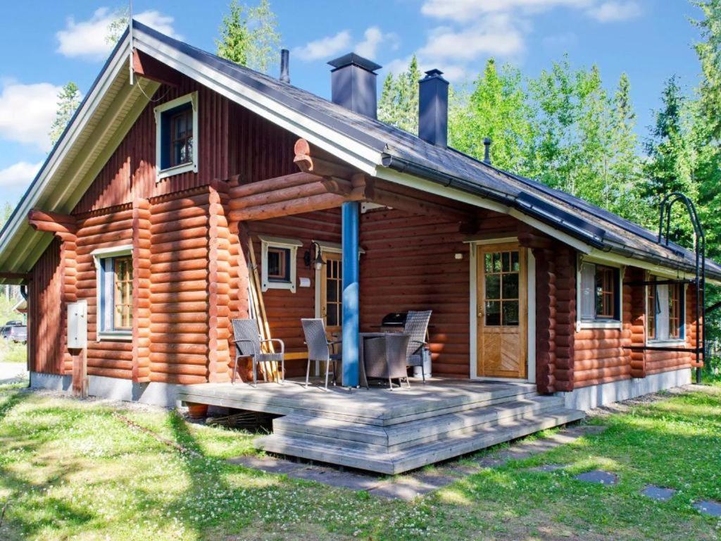 uma cabana de madeira com um alpendre e um deque em Holiday Home Amero purnu 3 em Kolinkylä