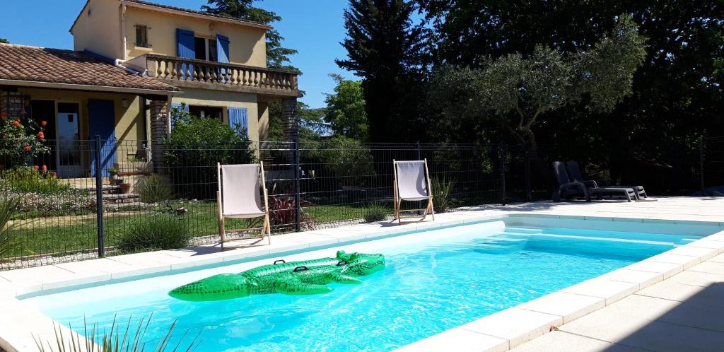 una piscina con una tortuga de juguete en el agua en Appartement neuf clim terrasse & piscine en Blauzac